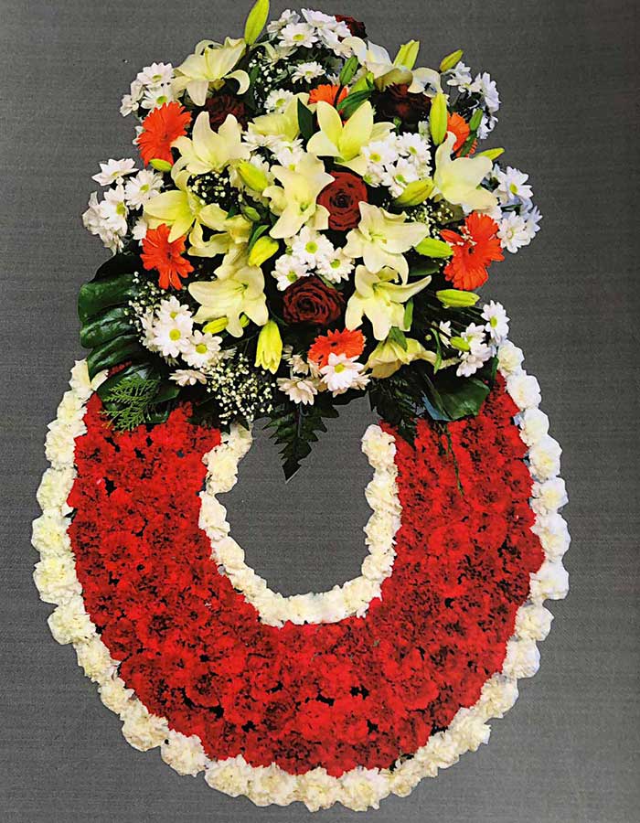 CORONA Nº 5 de claveles rojos con borde de claveles blancos y un cabezal de flores